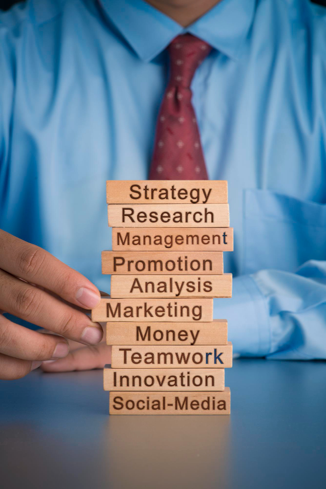 Midsection of businessman holding toy blocks with text on table