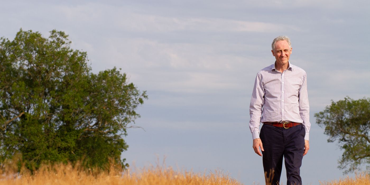 Man standing in a field with trees