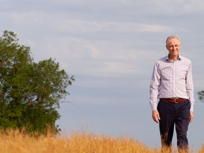 Man standing in a field with trees